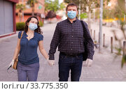 Couple in protective medical masks against coronavirus communicate on street. Стоковое фото, фотограф Яков Филимонов / Фотобанк Лори