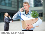 Young manager is talking phone and searching new job after dismissal. Стоковое фото, фотограф Яков Филимонов / Фотобанк Лори