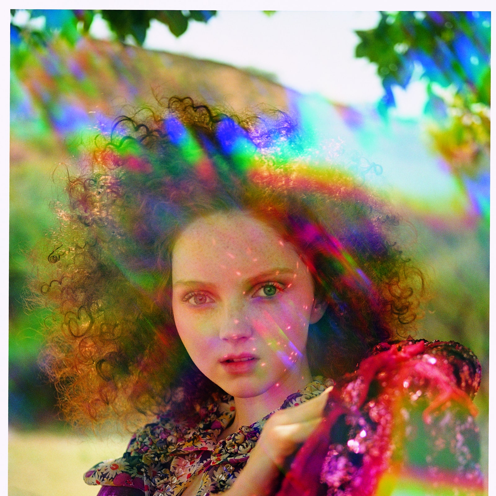 Model with rainbowprism light wears a silk daisy print blouse  sequin jacket bracelet and crystal necklace...