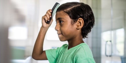 Boy combing his hair in the mirror