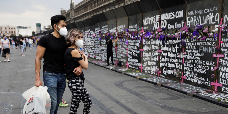 Visitors stand in front of the names of victims of femicide in Mexico outside the National Palace in Mexico City on March 7, 2021.