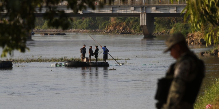 People travel across the Suchiate River from Guatemala to Mexico, as Mexican immigration agents enforce limits on all but essential travel at its shared border, near Ciudad Hidalgo, Mexico, on March 22, 2021.