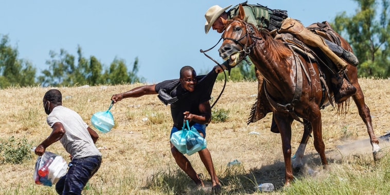 A border patrol agent on horseback tries to stop a Haitian migrant from entering an encampment on the banks of the Rio Grande near the Acuna Del Rio International Bridge in Del Rio, Texas, on Sept. 19, 2021.