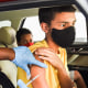 A nurse administers a COVID-19 vaccine to a kid at a drive-