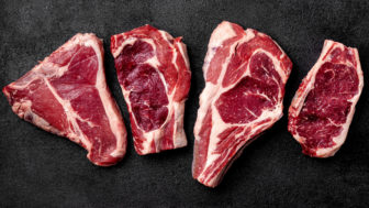 Meat raw steak lies on a black background. side view, copy space, top view