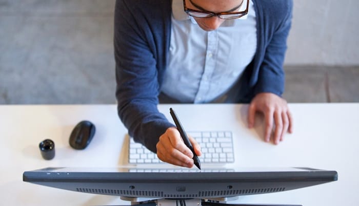 overhead of man on computer at desk