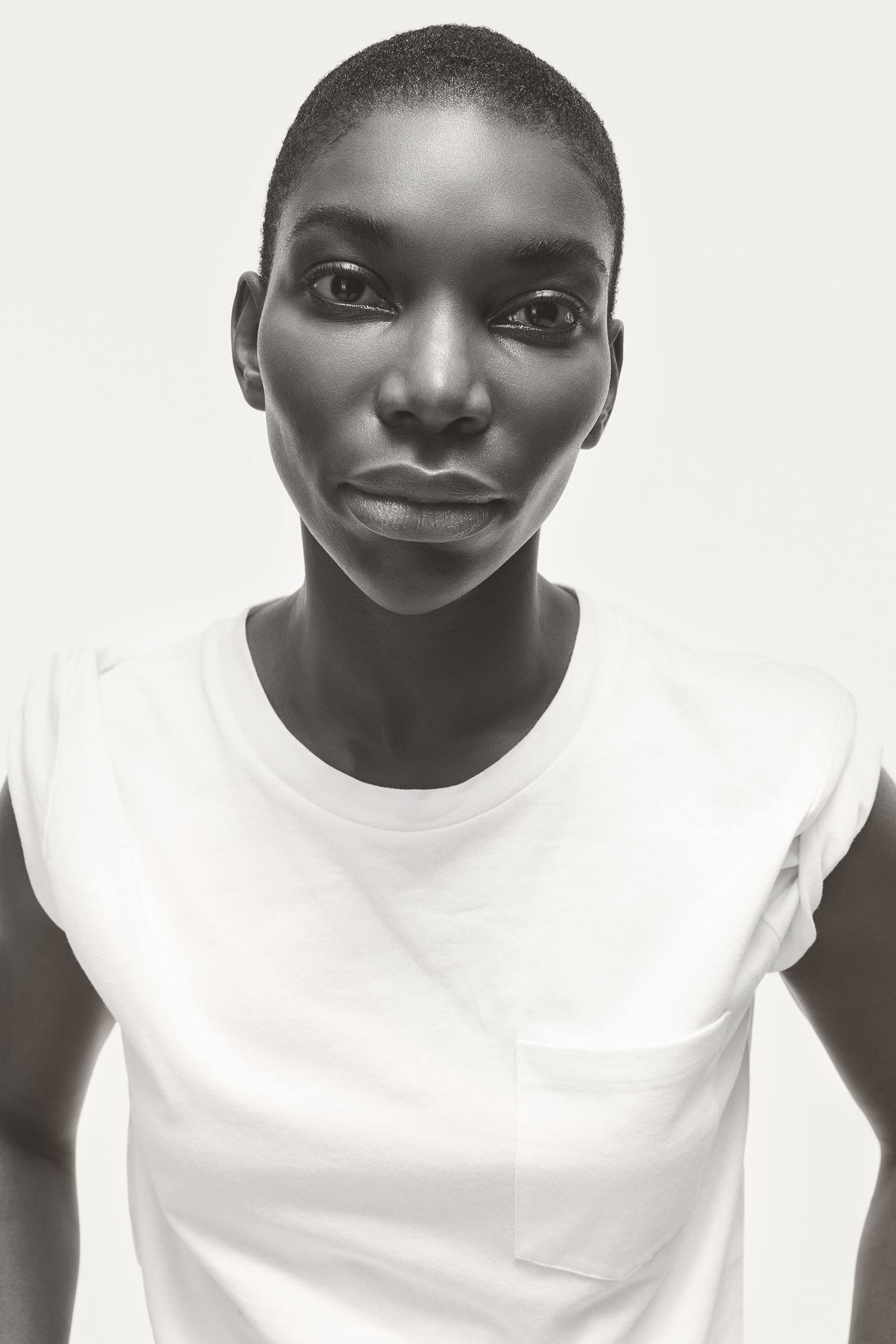 Portrait of Michaela Coel actress with shaved head wearing white t shirt