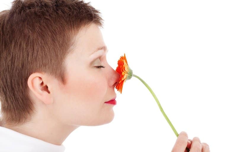 This shows a woman smelling a flower