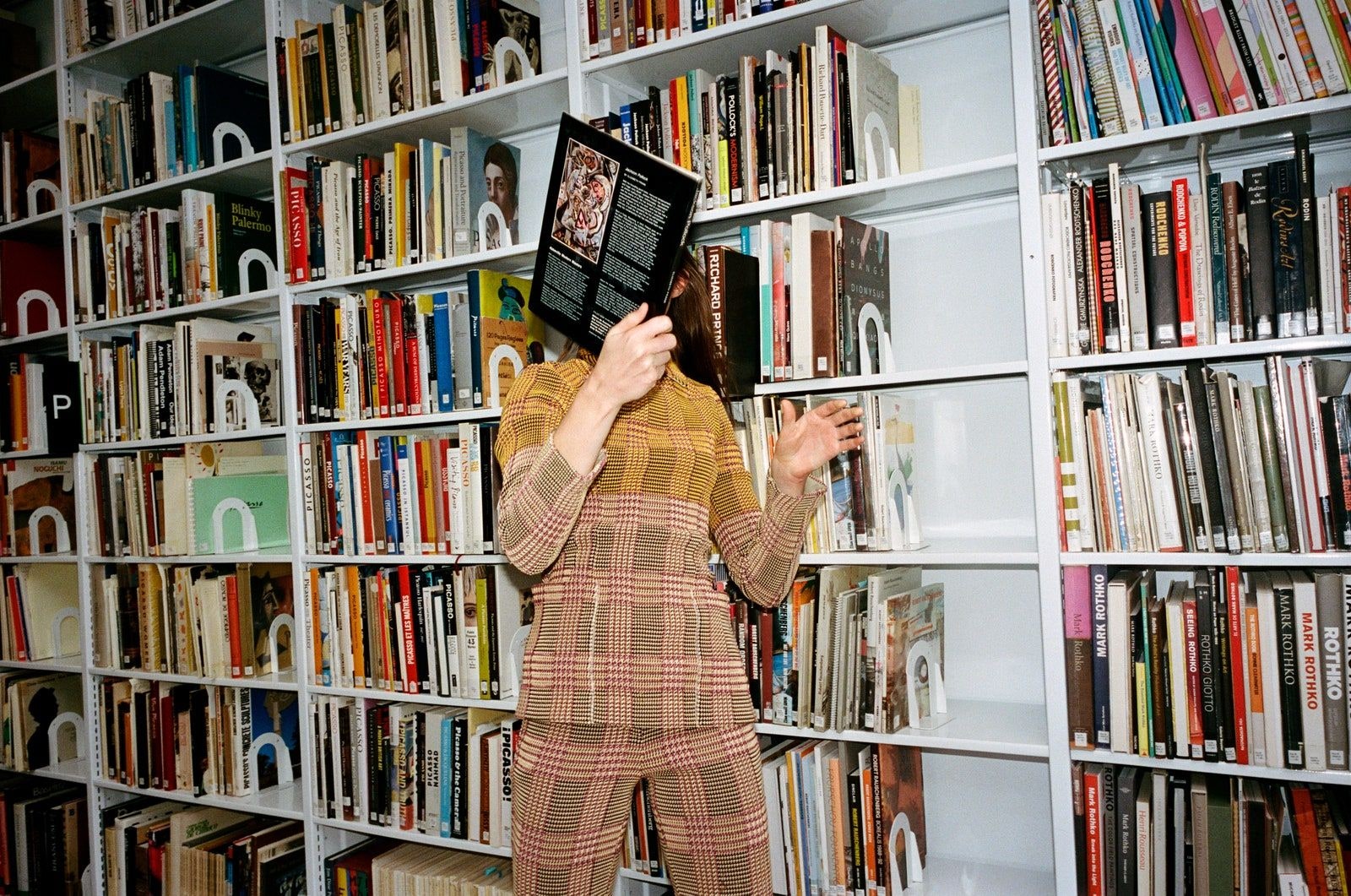 Model reading a book in a library