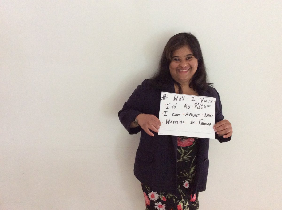 A young woman holding a sign that says "#Why I vote. It's my right. I care about what happens in Canada." 