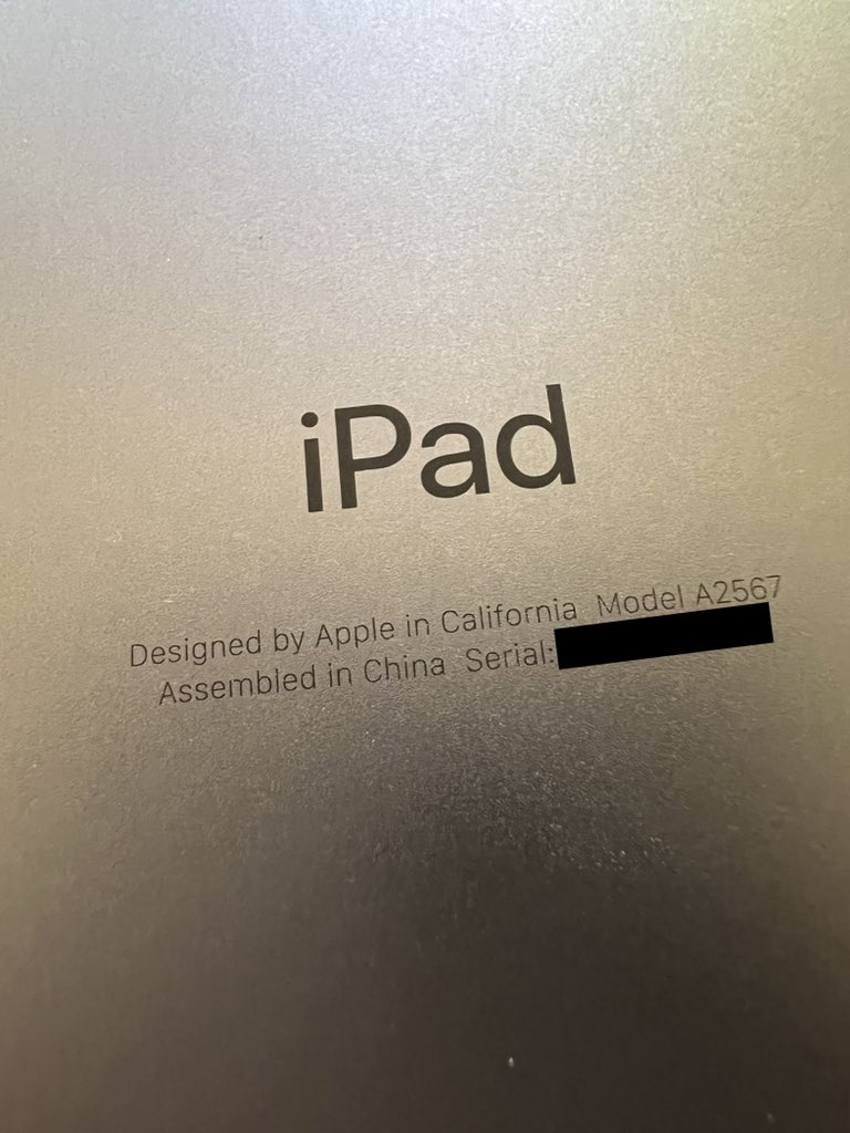 Back of an iPad mini in closeup on the small "Designed by Apple in California" text