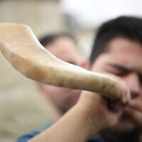 A Jewish man blows the shofar at the Rashbi gravesite in Meron, northern Israel, on September 9, 2017, prior to the Jewish holidays of Rosh Hashanah and Yom Kippur. (David Cohen/Flash90)