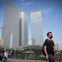 Israelis wear protective face masks near the Azrieli towers in Tel Aviv, on October 25, 2020. (Miriam Alster/Flash90)