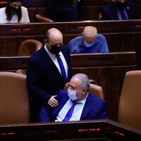 Prime Minister Naftali Bennett seen with Minister of Finance Avigdor Liberman during a vote on the first reading of the state budget in the Knesset, September 2, 2021. (Olivier Fitoussi/Flash90)