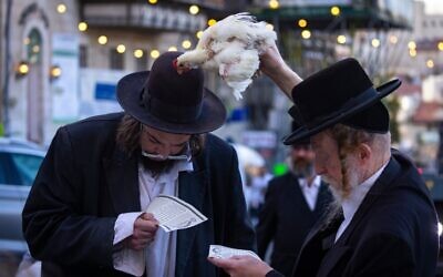 Ultra Orthodox Jews perform the Kapparot ceremony on September 13, 2021, in the Jerusalem neighborhood of Mea Shearim. (Olivier Fitoussi/Flash90)