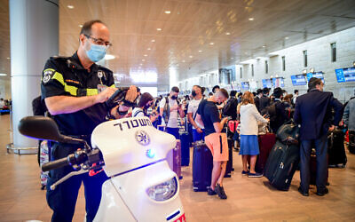 A police officer enforces COVID-19 regulations at Ben Gurion International Airport on July 19, 2021. (Avshalom Sassoni/Flash90)