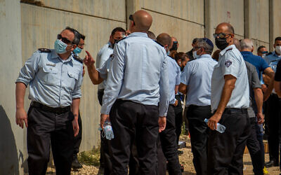 Police officers and prison guards stand at the scene of a prison escape of six Palestinian terrorists outside the Gilboa prison in northern Israel, on September 6, 2021. (Flash90)