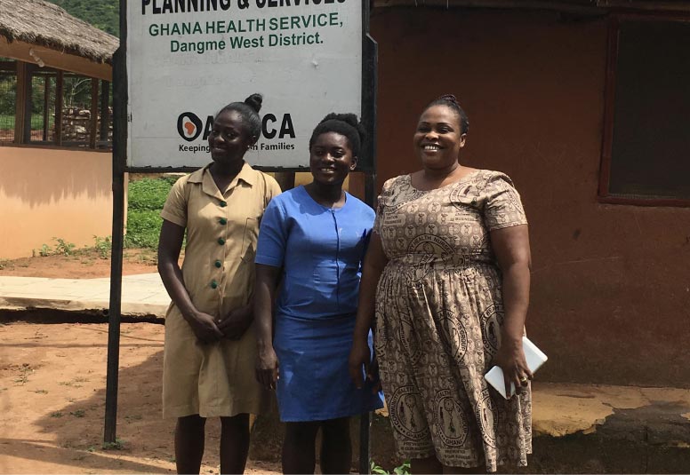 Three community health workers outside of a health facility near Accra, Ghana