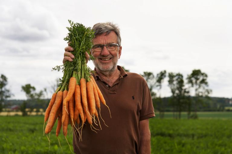 Bonde med høstens avling av norske gulrøtter