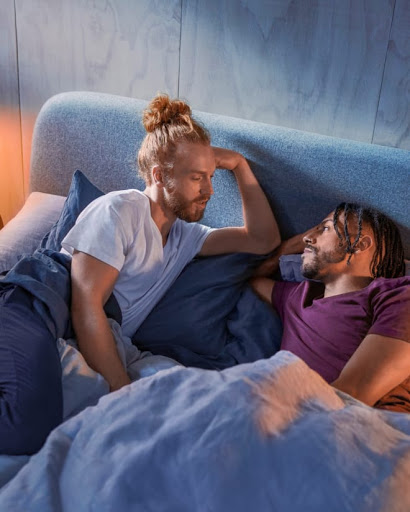 The man and his partner are comfy and cozy in bed.