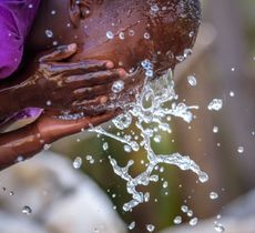 child splashing water on face