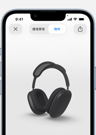 圖片顯示 iPhone 上擴增實境畫面中的太空灰色 AirPods Max。