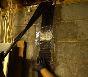 Crew installing carbon fiber basement wall repair
