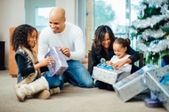 African american family opening presents under the christmas tree.