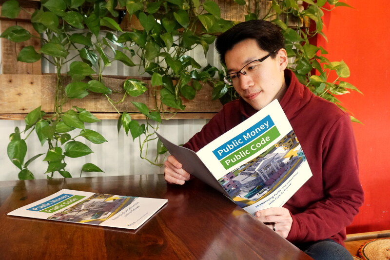 Interested reader with a Public Money Public Code brochure