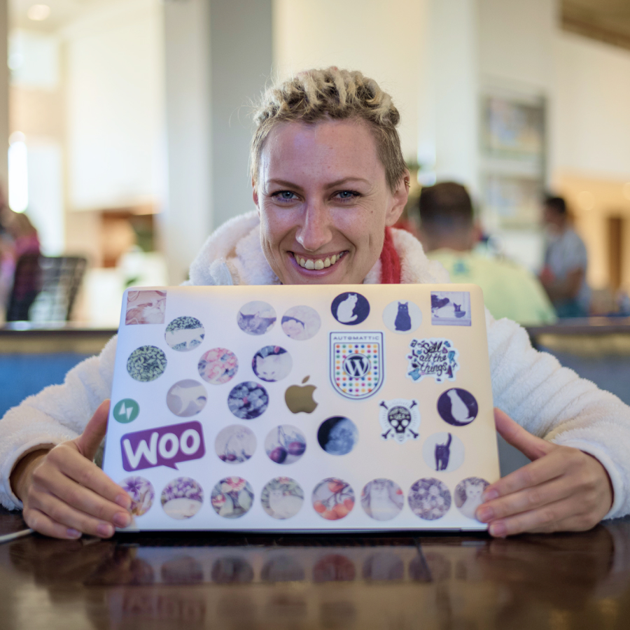 Woman smiling and showing her laptop filled with stickers