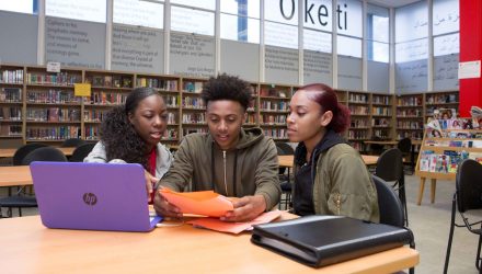 Two high school girls and a high school boy at a computer