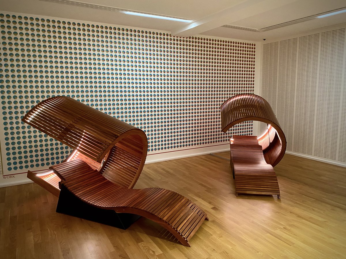 Wooden reclining chairs in a room full of graphs.