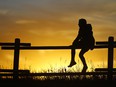 Caitlin Harvey watches the sunset in northwest Calgary on Monday, Oct. 4, 2021.