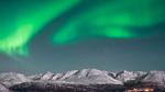 Nordlys over en nordnorsk fjord i mørketiden.