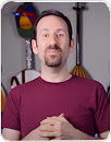 Man standing in front of guitars and a Google hat facing the camera.