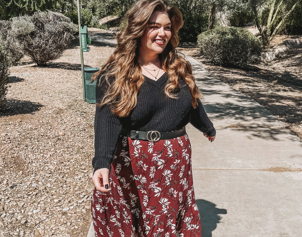 Plus Size Woman in Black V-Neck Sweater belted with Red Floral Print Maxi Skirt