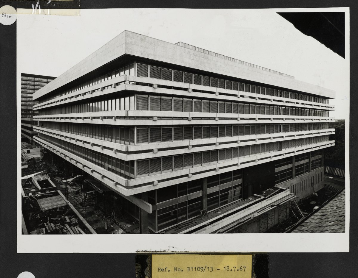 Black and white photograph of construction of Main Library from 1965-1967.  This photo shows the Main Library building almost complete, though there is still building works happening around the ground floor and basement level. In the background you can just about see the Business School, then Adam Ferguson Building, and 40 George Square.