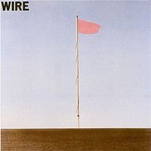 The album cover for the band Wire. The cover photo shows a single flagpole with a pink flag, against a blue sky.