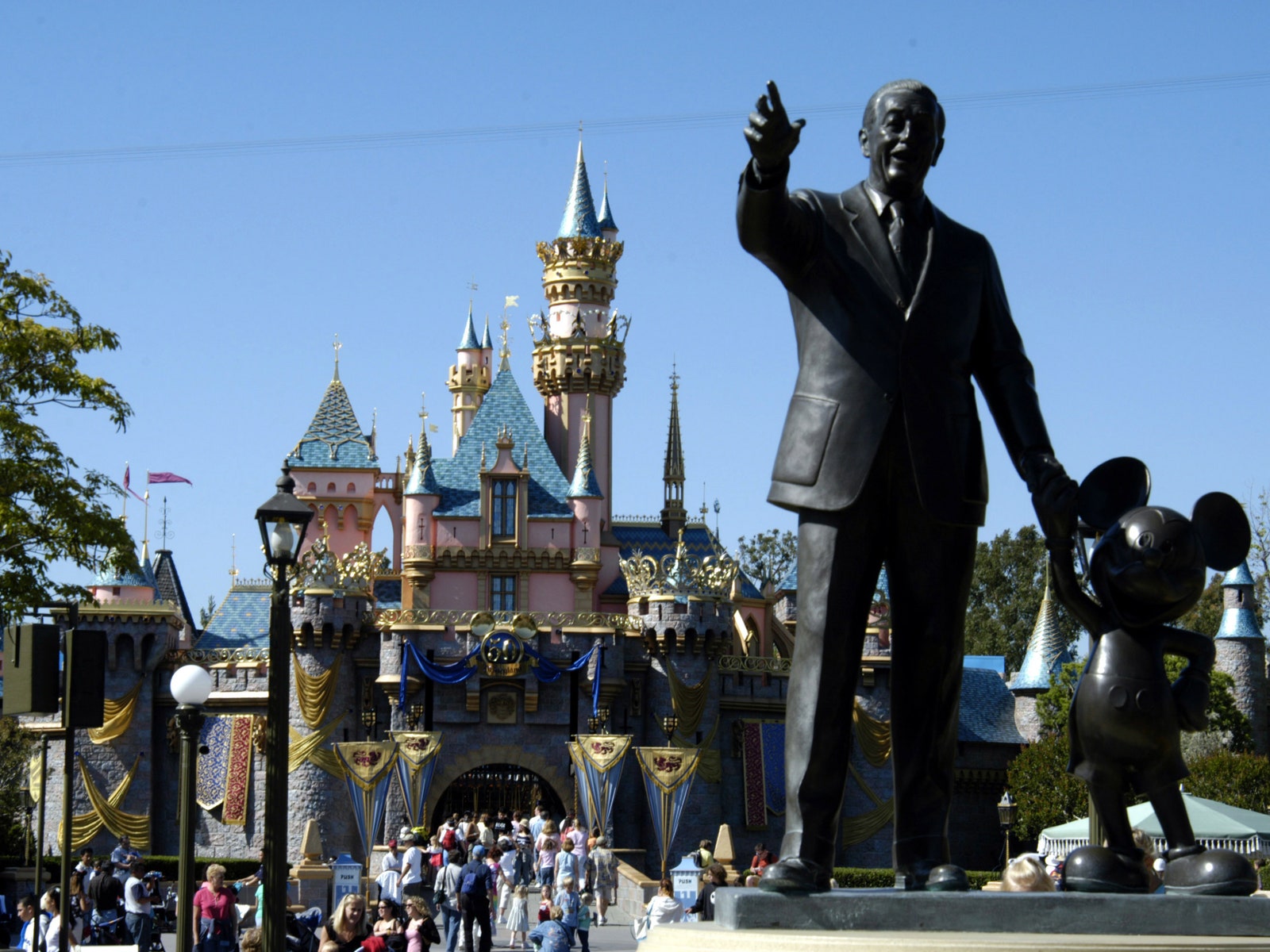 Sleeping Beauty's Castle and statue of Walt Disney and Mickey Mouse at the Disneyland Resort in Anaheim CA