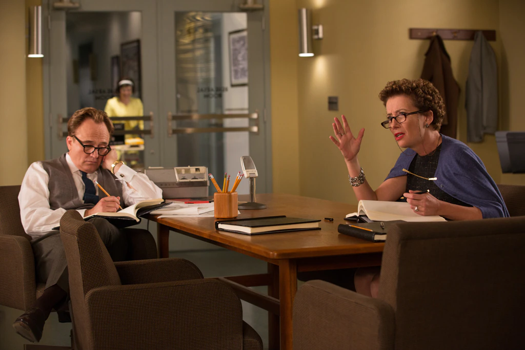 Actors Bradley Whitford (as Don DaGradi) and Emma Thompson (as P.L. Travers) sitting at a desk talking and writing in the movie "Saving Mr. Banks".