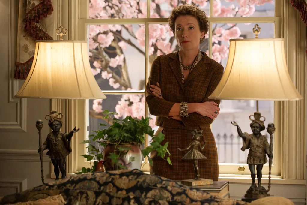 Actor Emma Thompson as P.L. Travers standing behind a couch between two lights in the movie "Saving Mr. Banks".