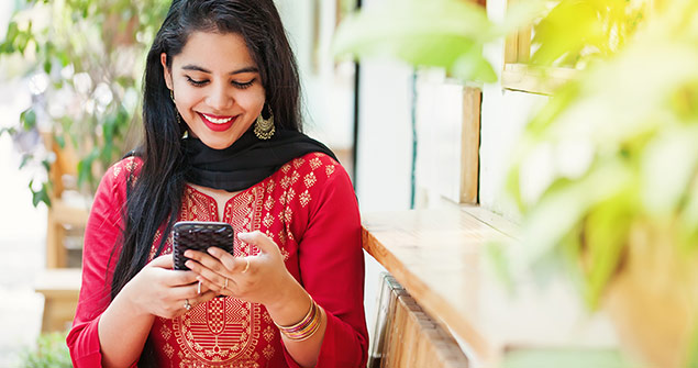 A woman on her smartphone smiling.