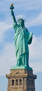 The Statue of Liberty, a large teal bronze sculpture on a stone pedestal