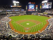 A baseball stadium from behind home plate in the evening.