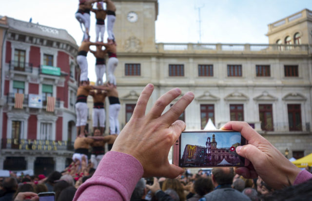 Hand held smartphone taking a picture of Castells Performance