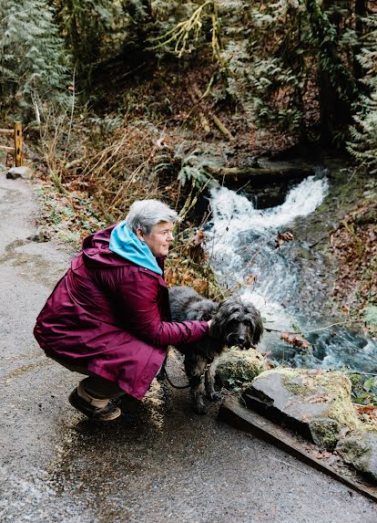 A woman pets a large grey dog as a way to support her wellbeing.