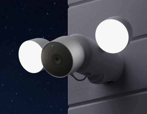 Nest Cam with the floodlight is on the side of a home and the lights are shining bright at night.