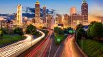 Highway with car lights leading to Atlanta at twilight.