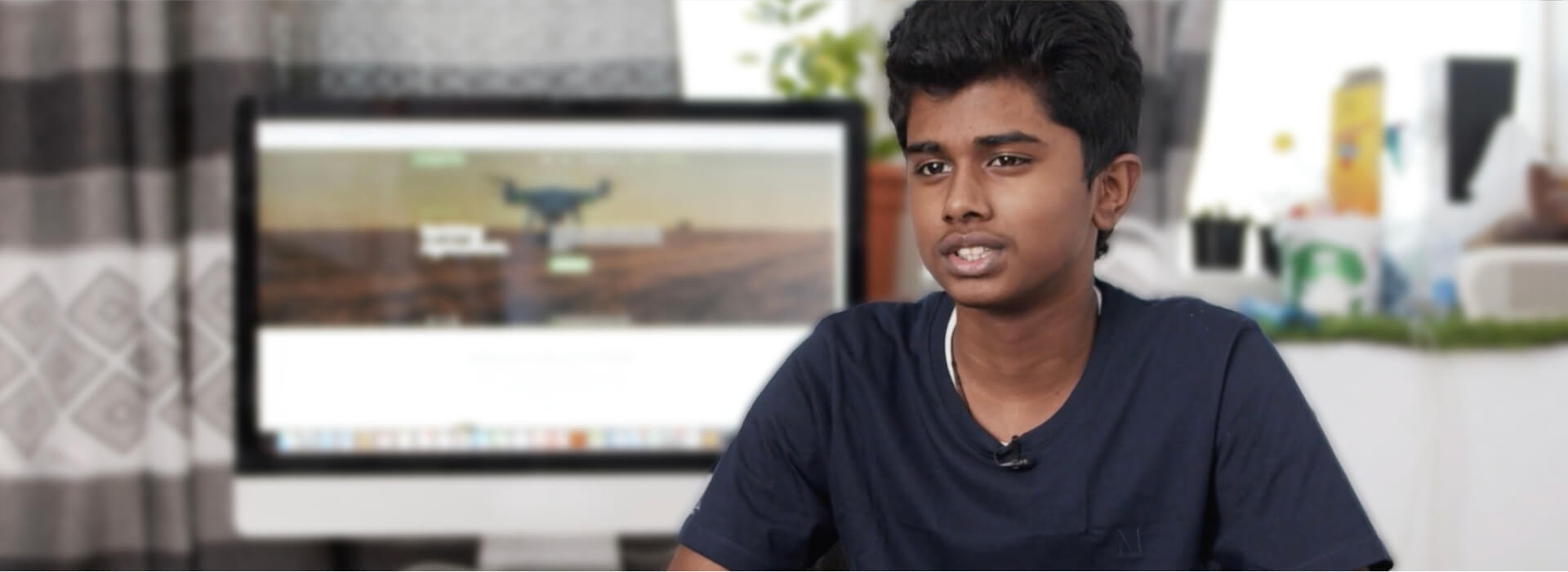 A person in a chair with a computer screen in the background.