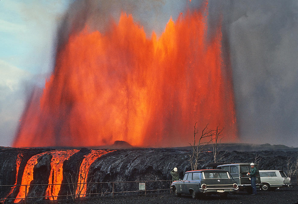 Image shows a lava fountain approx 1,000 ft high from Maunaulu vent area.  Cars parks in foreground of image. 